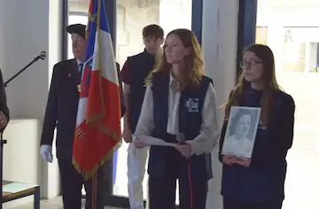 Sous sa plaque commémorative, deux élèves ont retracé le parcours d’Hélène Puthod. Photo Le DL/F.T.